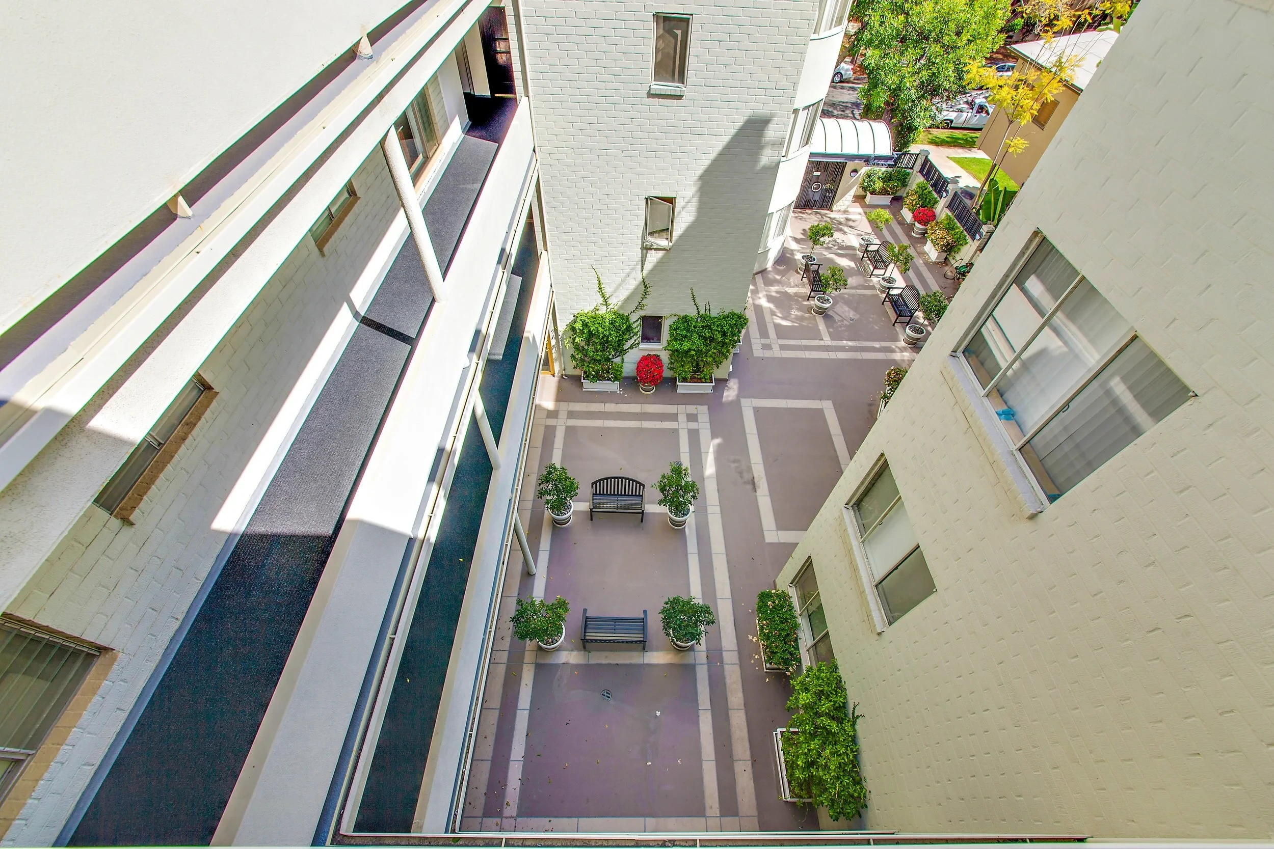 Aerial view of private courtyard with benches and lush greenery