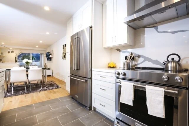 Kitchen with appliances and dining area beyond