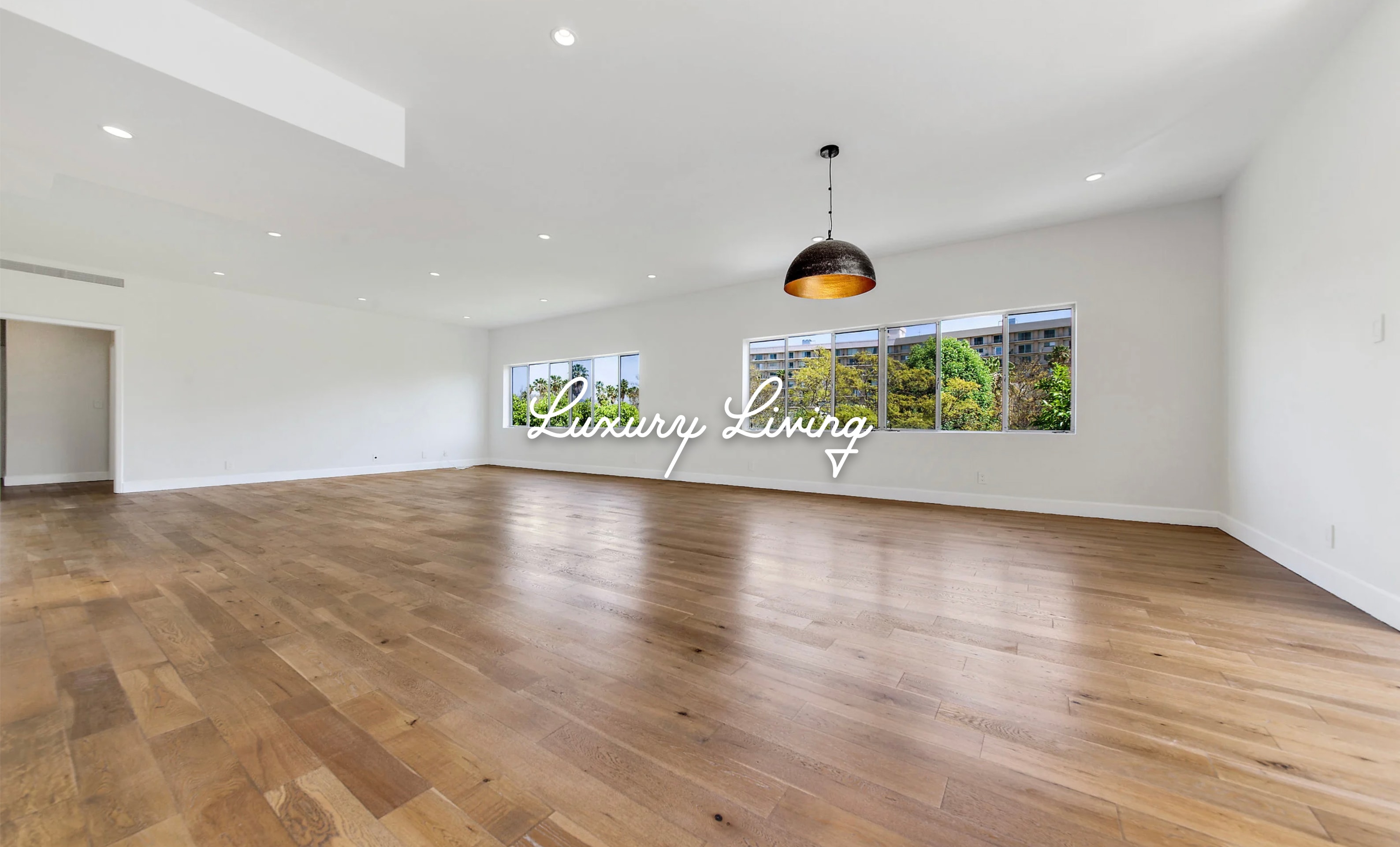 Spacious luxury living room with hardwood floors, recessed lighting and garden views